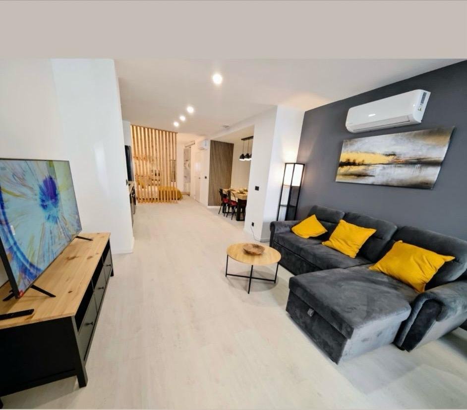 Salón reformado con zona de estar y acabados contemporáneos